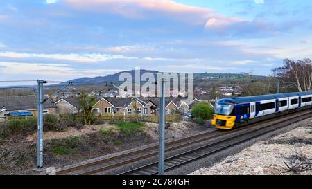 Northern Rail Personenverkehr Zug Reisen auf Wharfedale Line Bahngleise, vorbei an Häusern in ländlichen Dorf - Burley, Yorkshire, England, Großbritannien. Stockfoto