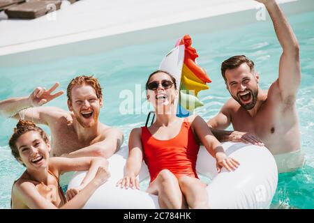 Gruppe junger Leute, die viel Zeit im Schwimmbad haben Stockfoto