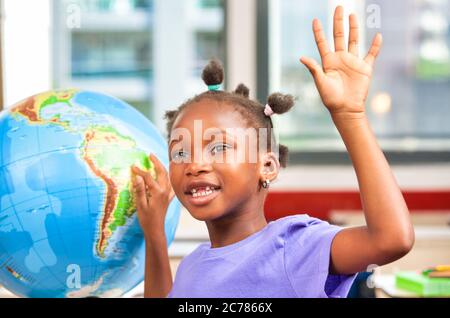 Grundschule Szene. Afrikanische Schulmädchen mit Welt Globus im Klassenzimmer. Stockfoto
