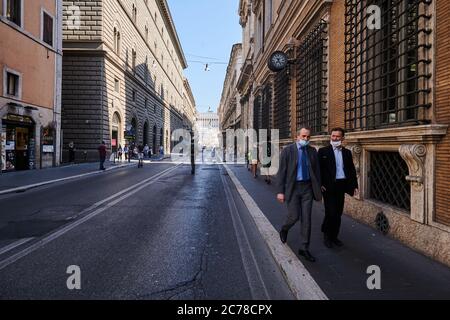 Rom, Italien. Juli 2020. Zwei Männer in Masken gehen auf einem Bürgersteig in Rom. Die Reisebeschränkungen aufgrund der Corona-Pandemie wurden wieder aufgehoben, doch die Straßen Roms scheinen im Juli noch recht leer zu sein. Quelle: Annette Riedl/dpa-Zentralbild/ZB/dpa/Alamy Live News Stockfoto