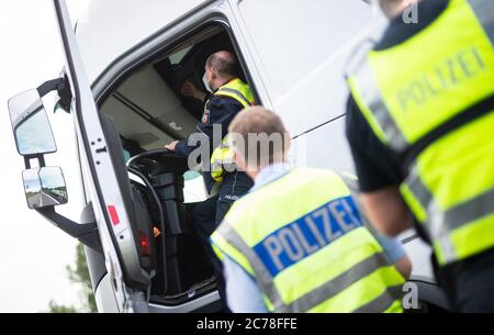 Unna, Deutschland. Juli 2020. Drei Polizisten kontrollieren einen LKW auf dem Kolberg-Parkplatz auf der Autobahn 2 in Richtung Hannover. Die Landpolizei Unna führt zusammen mit dem Landesamt für Bildung, Weiterbildung und Personalwesen (LAFP) und Zoll umfangreiche LKW-Kontrollen durch. Der Schwerpunkt der Kontrollen liegt auf der Einhaltung der Sozialvorschriften. Quelle: Jonas Güttler/dpa/Alamy Live News Stockfoto