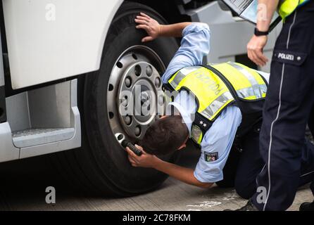 Unna, Deutschland. Juli 2020. Ein Polizist überprüft den Zustand der Bremsscheiben eines LKW auf dem Kolberg Parkplatz auf der Autobahn 2 in Richtung Hannover. Die Bezirkspolizei Unna führt zusammen mit dem Landesamt für Bildung, Weiterbildung und Personalwesen (LAFP) und Zoll umfangreiche LKW-Inspektionen durch. Der Schwerpunkt der Kontrollen liegt auf der Einhaltung der Sozialvorschriften. Quelle: Jonas Güttler/dpa/Alamy Live News Stockfoto