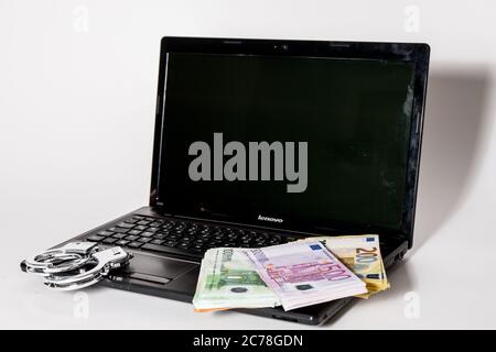 Bamberg, Deutschland 13. Juli 2020: Symbolische Bilder - 2020 mehrere Tausend Euro in bar mit den Werten von 500 Euro, 200 Euro, 100 Euro und 50 Euro liegen auf einem Laptop mit Handschellen, Cyberkriminalität, Cyberkriminalität, - weltweit Stockfoto