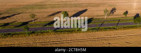 Grabow, Deutschland. Juli 2020. Reifes Getreide steht links und rechts von einer Landstraße. In vielen Regionen Sachsen-Anhalts läuft die Ernte auf Hochtouren. Luftaufnahme mit Drohne) Quelle: Stephan Schulz/dpa-Zentralbild/ZB/dpa/Alamy Live News Stockfoto