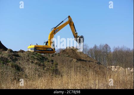 Der Bagger gräbt den Boden, der Bagger arbeitet als Eimer, Erdbewegungsmaschinen im Fall, Russland, Kaliningrad, 28. März 2020 Stockfoto