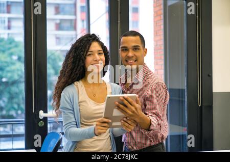 Zwei junge Kollegen folgen bei der Arbeit. Stockfoto