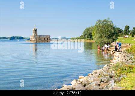 Normanton Church Rutland Wasserreservoir mit Menschen paddeln an der Ufer von Rutland Water Oakham Rutland England GB Europa Stockfoto