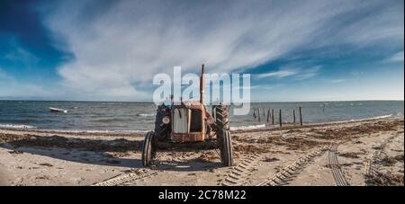 Rostiger Traktor an einem einsamen Strand in Dänemark Stockfoto