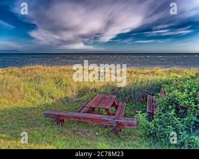 Bank und Tisch an einem einsamen Strand, Dänemark Stockfoto