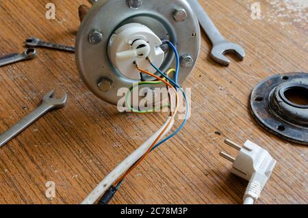 Flansch vor dem Einbau in das Kesselgehäuse. Details eines Heisswasserbereifens und Handwerkzeuge auf dem Tisch. Reparaturdienste für Haushaltsgeräte. Stockfoto