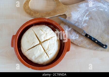 Brotteig mit Kreuz auf gesunde, hausgemachte irische Sodabrot in einer roten Keramikschale geschnitten. Hausbäckerei. Stockfoto