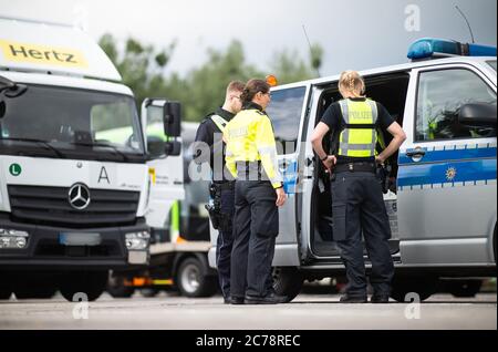 Unna, Deutschland. Juli 2020. Zwei Polizistinnen und ein Polizist stehen auf dem Kolberger Parkplatz auf der Autobahn 2 in Richtung Hannover an einem Einsatzfahrzeug. Die Landpolizei Unna führt zusammen mit dem Landesamt für Bildung, Weiterbildung und Personalwesen (LAFP) und Zoll umfangreiche LKW-Kontrollen durch. Der Schwerpunkt der Kontrollen liegt auf der Einhaltung der Sozialvorschriften. Quelle: Jonas Güttler/dpa - ACHTUNG: Kennzeichen wurde aus rechtlichen Gründen verpixelt/dpa/Alamy Live News Stockfoto