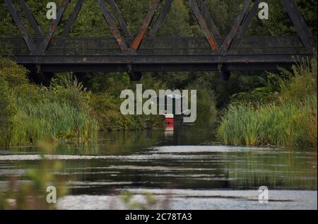 Ein Boot, das in der Ferne auf diesem Foto auf dem schönen Basingstoke Canal in Hampshire ruhte Stockfoto