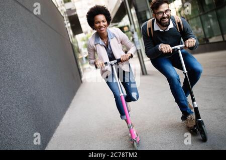 Schönes Paar, das Spaß hat, einen Elektro-Roller im Freien in der Stadt zu fahren Stockfoto