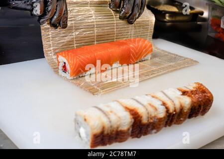 Der Prozess des Kochens von Sushi, die Rolle in einem Nori Blatt wickeln. Japanische Küche. Stockfoto