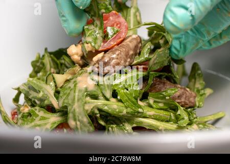 Kalbsbartensalat und pochiertes Ei. Warmer Salat mit Fleisch im Restaurant Stockfoto