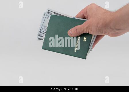 Hand hält grünen Pass mit usa-Dollar. Konzept - Bestechung und Korruption Stockfoto