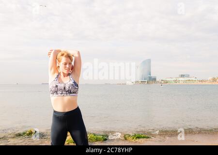 Schöne sportliche Frau, die sich vor dem Meer in der Stadt, gesunden Lebensstil und Sport-Konzept, Copy Space for Text Stockfoto