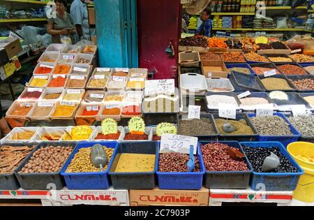 Akko Israel, Okt,9,2016:Leute kaufen bunte Gewürze, getrocknete Früchte, Nüsse, Samen und Oliven auf dem täglichen Straßenmarkt. Tags mit hebräischen Namen und Preis Stockfoto