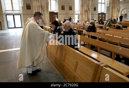 Canon Gerald Sharkey während der Comunion bei der ersten Messe in der St. Andrew's Cathedral in Glasgow seit dem 19. März, als Schottland sich auf die Aufhebung weiterer Beschränkungen für die Sperrung von Coronaviren vorbereitet. Stockfoto