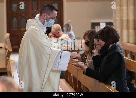 Canon Gerald Sharkey während der Comunion bei der ersten Messe in der St. Andrew's Cathedral in Glasgow seit dem 19. März, als Schottland sich auf die Aufhebung weiterer Beschränkungen für die Sperrung von Coronaviren vorbereitet. Stockfoto