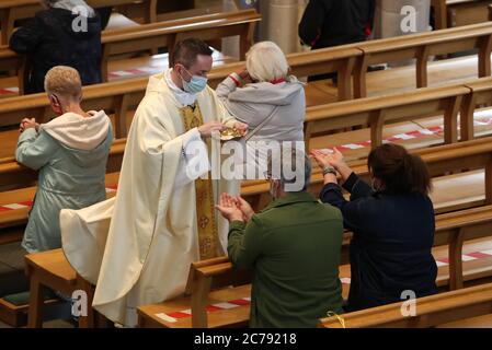 Canon Gerald Sharkey während der Comunion bei der ersten Messe in der St. Andrew's Cathedral in Glasgow seit dem 19. März, als Schottland sich auf die Aufhebung weiterer Beschränkungen für die Sperrung von Coronaviren vorbereitet. Stockfoto