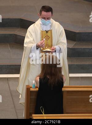 Canon Gerald Sharkey während der Comunion bei der ersten Messe in der St. Andrew's Cathedral in Glasgow seit dem 19. März, als Schottland sich auf die Aufhebung weiterer Beschränkungen für die Sperrung von Coronaviren vorbereitet. Stockfoto