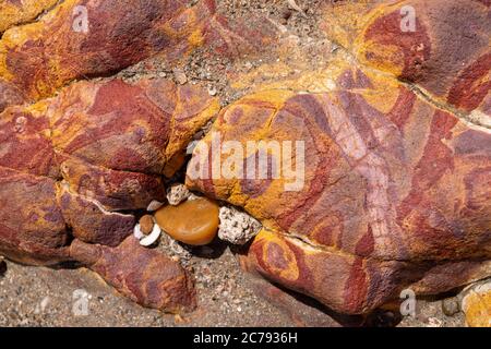 Farbenfrohe Sand und Sedimentgesteine, die abstrakte Muster am Strand von Peroba, Icapui, Ceara, Brasilien Stockfoto