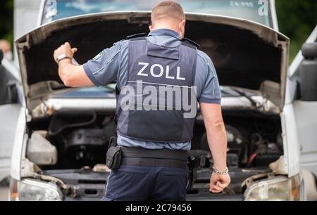 Unna, Deutschland. Juli 2020. Ein Zollbeamter kontrolliert einen Motorraum eines Fahrzeugs auf dem Parkplatz Kolberg auf der Autobahn 2 in Richtung Hannover. Die Landpolizei Unna führt zusammen mit dem Landesamt für Bildung, Weiterbildung und Personalwesen (LAFP) und Zoll umfangreiche LKW-Kontrollen durch. Der Schwerpunkt der Kontrollen liegt auf der Einhaltung der Sozialvorschriften. Quelle: Jonas Güttler/dpa/Alamy Live News Stockfoto