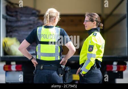 Unna, Deutschland. Juli 2020. Zwei Polizistinnen stehen auf dem Parkplatz Kolberg an der Autobahn 2 in Richtung Hannover an einem LKW. Die Landpolizei Unna führt zusammen mit dem Landesamt für Bildung, Weiterbildung und Personalwesen (LAFP) und Zoll umfangreiche LKW-Kontrollen durch. Der Schwerpunkt der Kontrollen liegt auf der Einhaltung der Sozialvorschriften. Quelle: Jonas Güttler/dpa - ACHTUNG: Kennzeichen des LKW wurde aus rechtlichen Gründen verpixelt/dpa/Alamy Live News Stockfoto