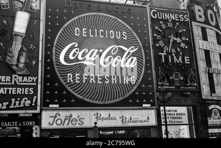 Vintage-Fotografie des Piccadilly Circus aus den 1950er Jahren in London, England. Zeigt die Neon-Werbezeichen der Ära, einschließlich Coca Cola, Guinness, Ever Ready. Stockfoto