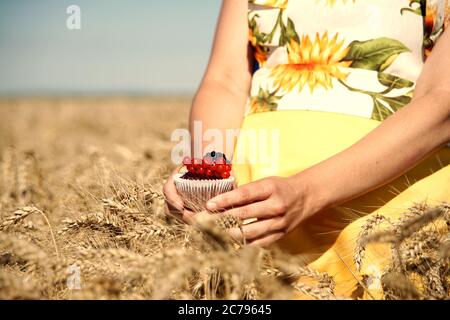 Mädchen hält einen Schokoladenmuffin mit Früchten verziert. Food-Fotografie. Stockfoto