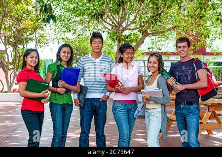 Multikulturelle Jugendliche Schulgruppe im Freien mit Studie Arbeitsmappen lächelnd ältere Teenager-Studenten 15-17 Jahre außerhalb auf Schulhof Campus Stockfoto