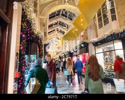 BURLINGTON ARCADE WEIHNACHTEN GESCHÄFTIGE SHOPPER LONDON FESTLICHE SCHAUFENSTER WEIHNACHTSEINKÄUFE SHOPPER INTERIEUR charmante Olde Worlde Burlington Arcade in seinem 200. Jahr in Piccadilly mit traditionellen Weihnachtsdekorationen funkelnde Lichter und Massen von Shopper in einem nobleren festlichen überdachten Einkaufsumfeld London UK Stockfoto