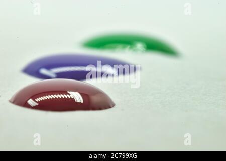 Ein schönes Nahaufnahme-Foto von Farbtropfen mit Spiegelung von Lichtern. Stockfoto