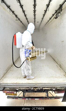 Peking, China. Juli 2020. Ein Mitarbeiter desinfiziert die Kühltransportanlage der Beijing Ershang Meat Food Group Co., Ltd. In Peking, Hauptstadt von China, 15. Juli 2020. Beijing Ershang Meat Food Group Co., Ltd. Ist eines der größten Unternehmen, das Fleisch für den Pekinger Markt liefert. Während der COVID-19 Pandemie hat das Unternehmen strenge COVID-19-Präventions- und Kontrollmaßnahmen entlang der gesamten Lieferkette ergriffen, um die Sicherheit von Fleischprodukten und den regelmäßigen Betrieb seiner Verarbeitungsfabriken zu gewährleisten, um der Marktnachfrage gerecht zu werden. Quelle: Li Xin/Xinhua/Alamy Live News Stockfoto