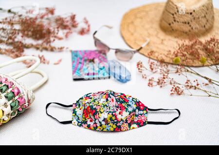 Frauen Coronavirus Gesichtsmaske mit wesentlichen Urlaub Reise Artikel für einen Urlaub in der Covid-19 Pandemie Stockfoto
