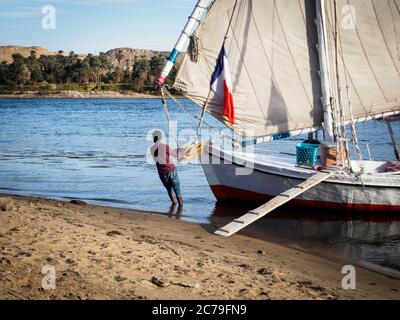 Ein Seemann bringt die Feluca an Land auf dem nil in ägypten Stockfoto