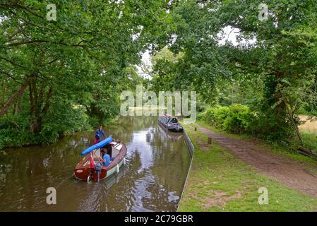 Ein schmales Boot und eine kleine Yacht auf dem Fluss Wey Navigation in der Nähe von Newark, Pyrford Surrey England Stockfoto