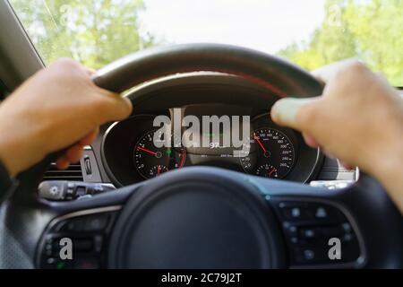 Nahaufnahme einer männlichen Hand am Lenkrad in einem modernen Auto Stockfoto