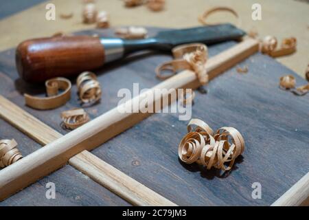 Geigenbaubank mit Werkzeug und Rückenteil einer akustischen Gitarre im Bau Stockfoto