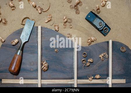 Geigenbaubank mit Werkzeug und Rückenteil einer akustischen Gitarre im Bau Stockfoto