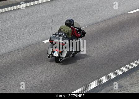 Ein Paar, das mit einem Motorrad (Harley Davidson) im Verkehr auf der Autobahn E4 unterwegs ist. Foto Jeppe Gustafsson Stockfoto