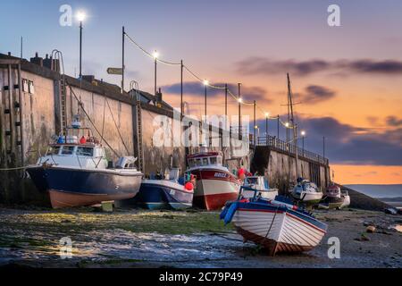 Dämmerung vor Sonnenaufgang auf dem Fluss Torridge, während die kleinen Fischerboote am Kai in Appledore in North Devon auf die ankommende Flut warten, bevor st Stockfoto