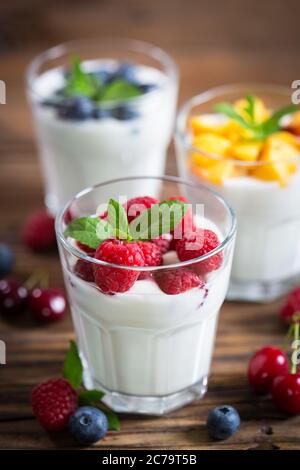 Frischer Fruchtjoghurt mit frischen Beeren und Pfirsichen Stockfoto