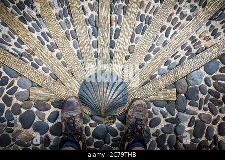 Der Weg von saint James oder compostelle. Gut getragene Wanderschuhe mit Muschel.Nasbinals Lozere, Frankreich. Stockfoto