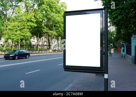 Leere weiße Stadtlicht in der Nähe der Straße und Park. Leere vertikale Plakatwand auf der Straße im Sommer, Blank Vorlage Stockfoto