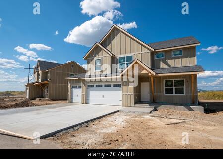 Ein neues Bauhaus, das noch im Bau ist, mit einer Garage für 3 Autos, steigt in einer Spokane, Washington Unterteilung von neuen Häusern auf. Stockfoto