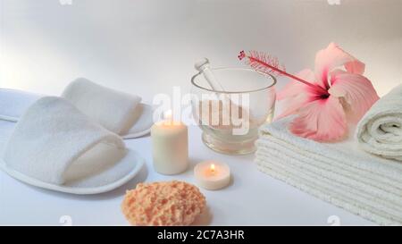 Spa-Ambiente und Spa-Hintergrund Komposition mit Hibiskusrosa Blume auf weißem Hintergrund. Banner. Speicherplatz kopieren. Handtuch, Kerzen, Blumen, Steine . Massa Stockfoto