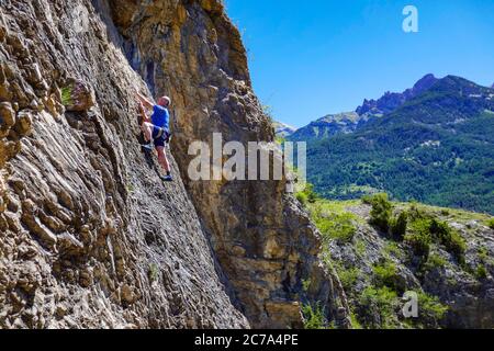 Reifer männlicher Bergsteiger auf einer Klippe im Ecrins Nationalpark, in der Nähe von Briançon, Frankreich Stockfoto